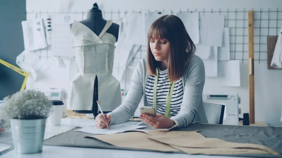 Spazio di lavoro creativo di un designer di moda con tessuti e schizzi.